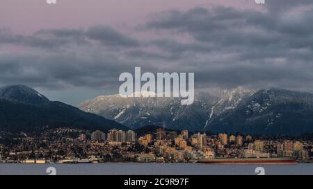 Die Stadt North Vancouver ist im Winter von verschneiten Bergen umgeben Stockfoto