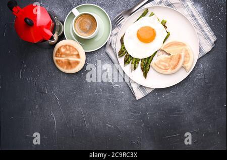 Gesundes Frühstück. Spiegeleier, Spargel, Brot und aromatischer Kaffee auf grauem Hintergrund. Freier Platz für Text. Weichfokus. Oben. Hochwertige Fotos Stockfoto