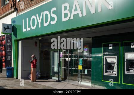 London, Großbritannien - 03. Februar 2019: Unbekannte Frau, die am sonnigen Morgen vor der Lloyds Bank-Filiale in Lewisham ihr Handy überprüft. Es ist ein o Stockfoto