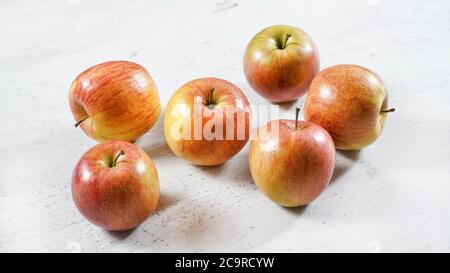Rot / gelb glänzende Äpfel (kiku Sorte) auf weißem Arbeitsbrett Stockfoto