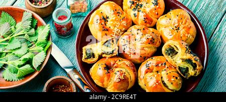 Hausgemachte rustikale Brennnessel und Spinat Brötchen auf Holztisch Stockfoto