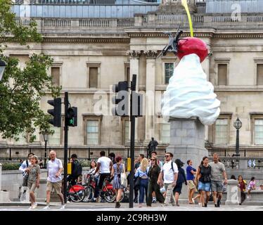 London, Großbritannien. August 2020. Touristen sehen sich die Skulptur an, die einen riesigen Strudel aus Schlagsahne, Kirsche, Fliege und Drohne hat, die ein lebendes Futter des Trafalgar Square überträgt. Ein neues Kunstwerk der Künstlerin Heather Phillipson mit dem Titel "THE END" wird nun auf dem vierten Sockel des Londoner Trafalgar Square enthüllt. Kredit: SOPA Images Limited/Alamy Live Nachrichten Stockfoto