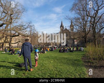 Tschechische Republik, Prag, 10. April 2018: Gruppe von Menschen entspannen auf üppigem grünen Gras und genießen Sie den frühen Frühlingstag auf Karlinske namesti Platz Park Stockfoto