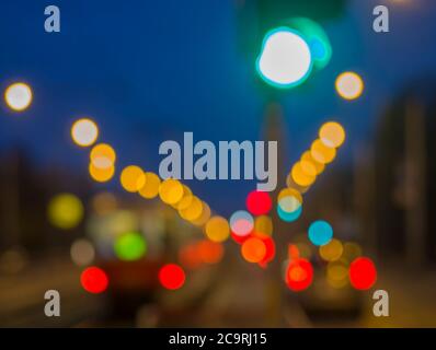 Bunte, unscharfe Ampeln mit unscharf beleuchteter Straßenbahn und Autos während des Twitelens Stockfoto