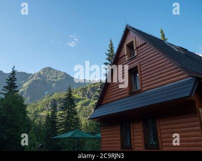 Slowakei, Westtatra, Rohacska dolina, 2. Juli 2019: Blick auf die Berghütte Tatliakova Chata, Holzhütte mit grünen Berggipfeln Stockfoto