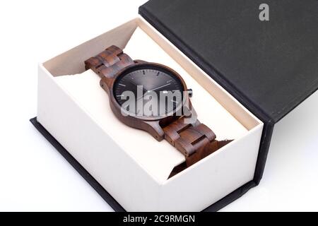Braune Armbanduhr aus Holz verpackt in offener Box von oben, auf weißem Hintergrund. Stockfoto