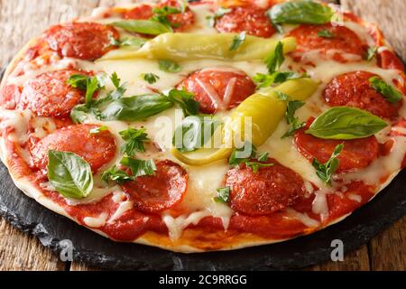 Köstliche Pizza mit Chorizo Chili Paprika, Mozzarella-Käse, Tomaten und Kräutern Nahaufnahme auf dem Brett auf dem Tisch. Horizontal Stockfoto