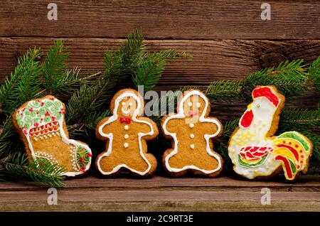 Lebkuchen: Socke, Hahn, Lebkuchen Männer. Pelzbaum Ast vor dem Hintergrund einer Holzwand mit Platz für Text Stockfoto