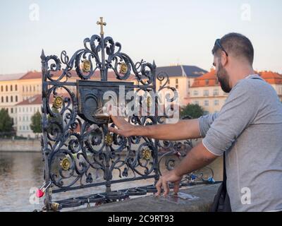 Tschechische Republik, Prag , 8. September 2018: Junger Mann Tourist berühren den fallenden Priester Heiligen Johannes von Nepomuk auf der Bronzetafel auf dekorativ Stockfoto