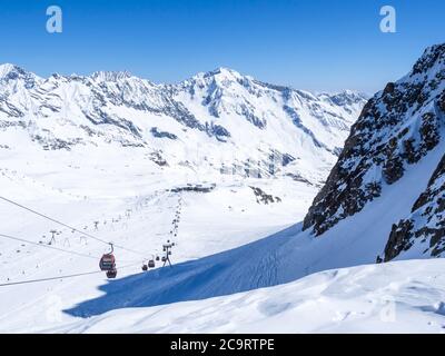 Stubaier Gletscher, ÖSTERREICH, 2. Mai 2019: Schneebedeckte Pisten mit freien Fahrten und Pisten und roten Bergbahnen und Sesselliften auf dem Gipfel der Scha Stockfoto