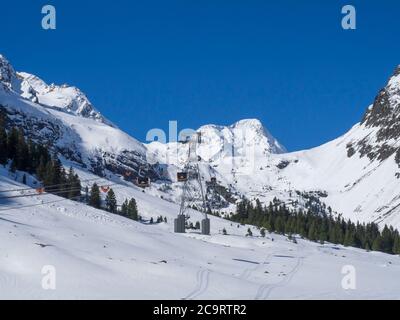 Stubaier Gletscher, Österreich, 2. Mai 2019: Verschneite Pisten mit modernen großen orangefarbenen Bergbahnen im Skigebiet Stubaier Gletscher, Tirol Stockfoto