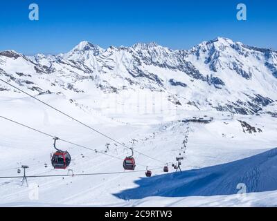 Stubaier Gletscher, ÖSTERREICH, 2. Mai 2019: Schneebedeckte Pisten mit freien Fahrten und Pisten und roten Bergbahnen und Sesselliften auf dem Gipfel der Scha Stockfoto