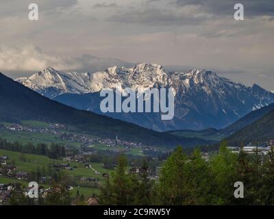 Frühling Berg ländliche Landschaft. Blick über das Stubaital Stubaital bei Innsbruck, Österreich mit Dorf Neder, grüne Wiese, Wald, schneebedeckte alpe Stockfoto