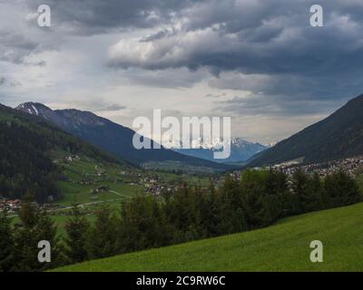 Frühling Berg ländliche Landschaft. Blick über das Stubaital Stubaital bei Innsbruck, Österreich mit Dorf Neder, grüne Wiese, Wald, schneebedeckte alpe Stockfoto