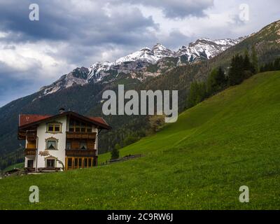 Üppige grüne Wiese, idyllische Frühlingsberg ländliche Landschaft. Blick über Stubaital oder Stubaital bei Innsbruck, Österreich mit rustikalem Holzhaus in Stockfoto