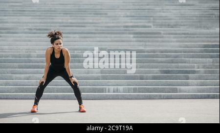 Fit junge Frau dabei Cardio-Training. Müde Mädchen mit Fitness-Tracker und drahtlose Kopfhörer Ruhe von der Ausübung auf der Stadttreppe Stockfoto