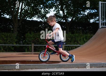 Vierjähriger Junge spielt auf einem Laufrad in einem Skatepark in Ilkley West Yorkshire Stockfoto