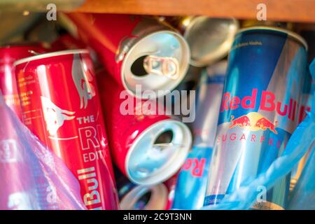 Split Kroatien August 2020 leere rote Bulle rot Rubin und blau zuckerfreie Dosen in Müll, Recycling gebrauchte Aluminium Energy Drinks Stockfoto
