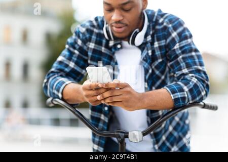 Portrait von afroamerikanischen Kerl SMS auf dem Smartphone Stockfoto
