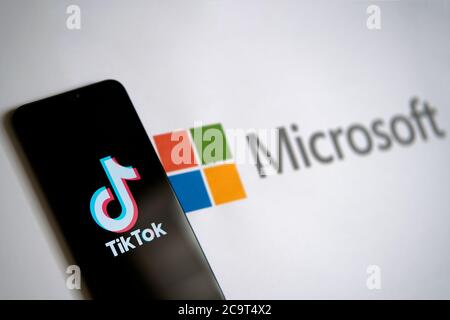 Stone / UK - 2. August 2020: TikTok App auf dem mobilen Bildschirm und Microsoft-Logo auf dem Papier zu sehen. Selektiver Fokus. Stockfoto