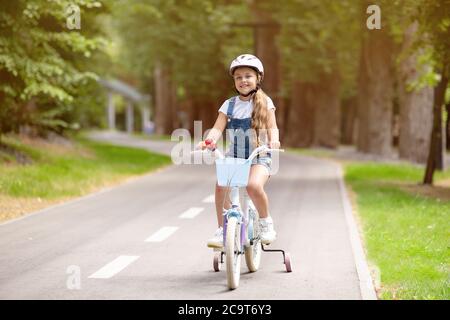 Kleines Mädchen Reiten Fahrrad Tragen Schutzhelm Mit Spaß Im Freien Stockfoto