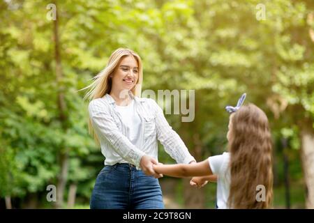 Glücklich Mutter Und Tochter Spinning Halten Hände Mit Spaß Im Freien Stockfoto