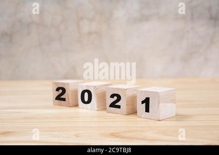 2021 frohes neues Jahr auf Holzblock auf Holztisch und grauem Hintergrund. Neujahr Konzept. Stockfoto