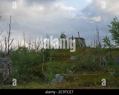 Abadoned Sami Hütte Goathi in grünen Hügeln Landschaft des Abisko National Park. Goahti ist lappische traditionelle Behausung aus Stoff, Torfmoos und Stockfoto