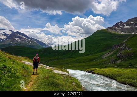 Wanderweibchen mit rotem Rucksack im Tal La Lenta, unter dem Col d'Iseran, Nationalpark Vanoise, Frankreich Stockfoto