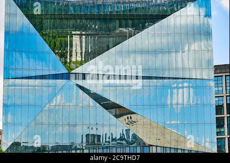 Berlin, Deutschland - 14. Juni 2020: Eine Glasfassade, die den Berliner Reichstag und die Schweizer Botschaft im Regierungsbezirk Berlin widerspiegelt. Stockfoto