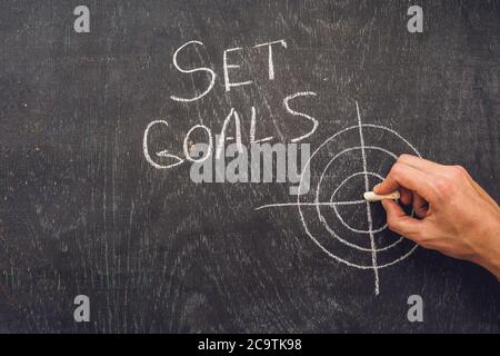 Handschriftlich Ziele festlegen Thema auf dem Schwarzen Brett Stockfoto