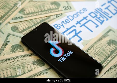 Stone / UK - 2. August 2020: TikTok App-Logo auf dem Telefon, das Weiße Haus auf 20-Dollar-Scheinen und das Bytedance Company-Logo auf dem unscharfen Hintergrund. Se Stockfoto