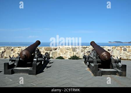 Ein paar alte rostige Kanonen auf der Promenade entlang der Strandpromenade von Alghero Stockfoto