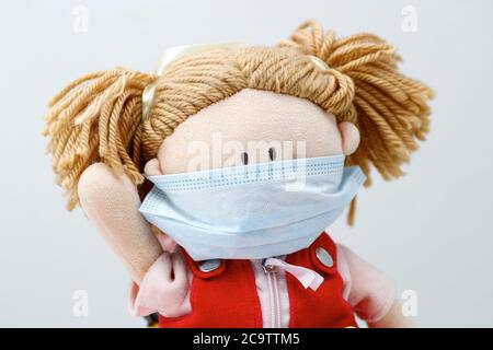 Puppe mit medizinischer Maske, um seine Verwendung in der Kindheit zu empfehlen. Gesundheitsschutz und Prävention während covid-19 und infektiösen Ausbruch Stockfoto
