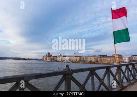 Die ungarische Flagge über der Donau auf der Kettenbrücke mit Blick auf das Parlamentsgebäude in Budapest. Stockfoto