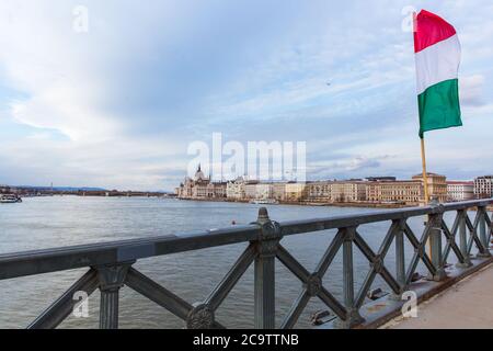 Die ungarische Flagge über der Donau auf der Kettenbrücke mit Blick auf das Parlamentsgebäude in Budapest. Stockfoto