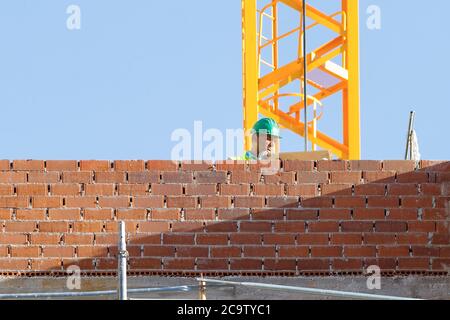 Madrid, Spanien - 22. Mai 2020: Arbeiter baut eine Ziegelmauer Stockfoto