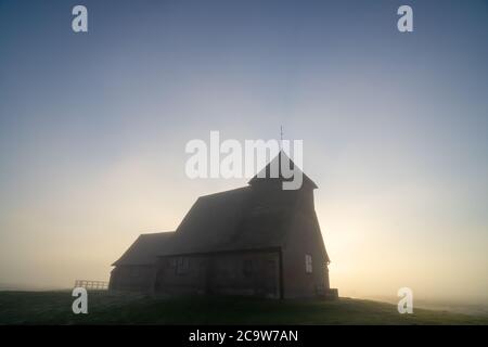 St. Thomas à Becket Kirche in Fairfield mit der Sonne durch den Nebel hinter der Kirche. Stockfoto