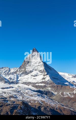 Atemberaubende Nahaufnahme des berühmten Matterhorn-Gipfels der Schweizer Alpen an sonnigen Herbsttag mit Schnee und blauer Himmelswolke, von der Seilbahn Trockener S Stockfoto