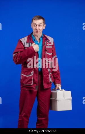 Krankenwagen Arzt Mann in einem Arbeitsanzug und mit einem Box in den Händen posiert auf einem blauen Hintergrund Stockfoto