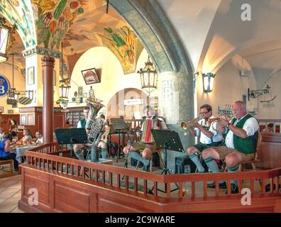 Die Oompah-Band im Münchner Hofbräuhaus ist in traditionelle bayerische Liederhosen gekostümiert und unterhält Gäste mit typisch bayerischer Musik. Stockfoto