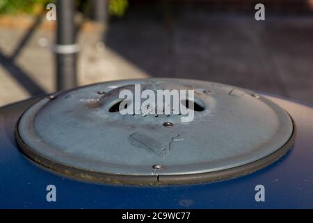 Nahaufnahme der Aschenbecher auf einer roten Eisen Gartentisch auf einer Garten  Wiese steht Stockfotografie - Alamy