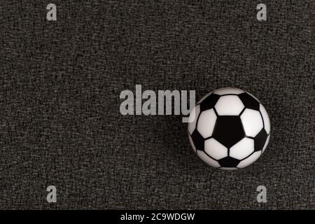 Kleiner Spielzeugfußball auf schwarzem Hintergrund. Nahaufnahme. Stockfoto