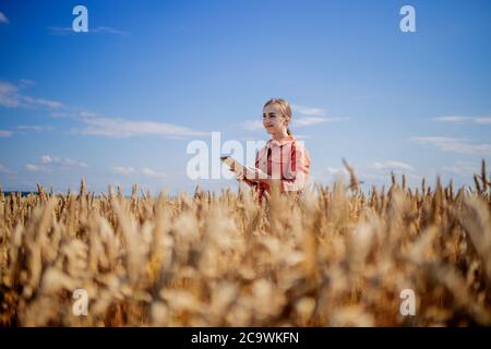 Frau kaukasische Technologin Agronomin mit Tablet-Computer auf dem Gebiet der Weizenprüfung Qualität und Wachstum von Kulturen für die Landwirtschaft. Landwirtschaft Stockfoto