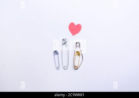 Schwangere Metallstifte mit rotem Herz. Zweites Kind. Stockfoto