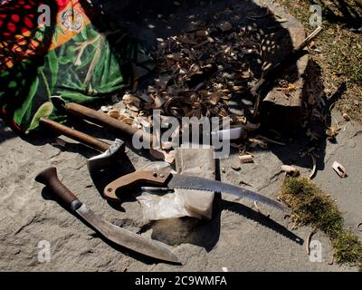Eine Säge, ein Messer und ein Hammer im Freien auf Steinboden Stockfoto