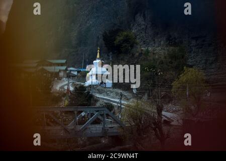 Buddhistische Stupa durch Gebetsfahnen im Chame Bergdorf gesehen, Trekking Annapurna Circuit, Nepal Stockfoto