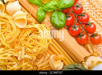 Eine Gruppe von verschiedenen Arten von italienischen Pasta. Traditionelle Pasta aus verschiedenen Regionen italiens und frisches grünes Basilikum. Zutaten zum Kochen. Freier Speicherplatz für Text. Hochwertige Fotos Stockfoto