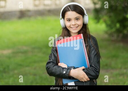 Mädchen hören Audio tragen Lehrbücher auf dem Weg zur Schule, Schule Club Konzept. Stockfoto