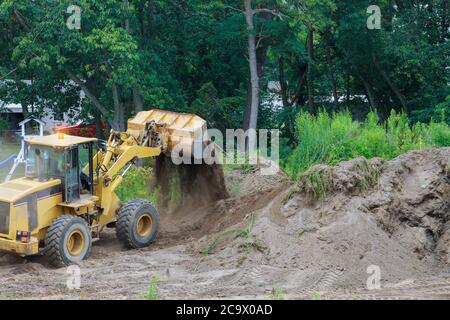 Bulldozer Landschaftsbau arbeitet auf Bau arbeiten mit Erde, während Scoop Bagger Stockfoto